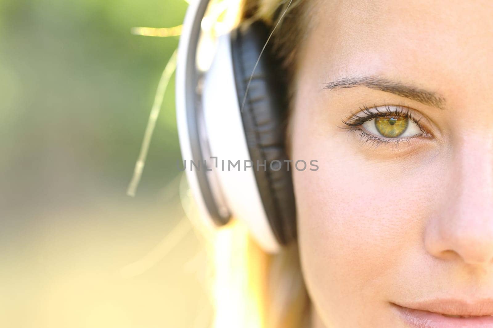 Front view close up of a beautiful woman wearing headphone with amazing eye looks at you