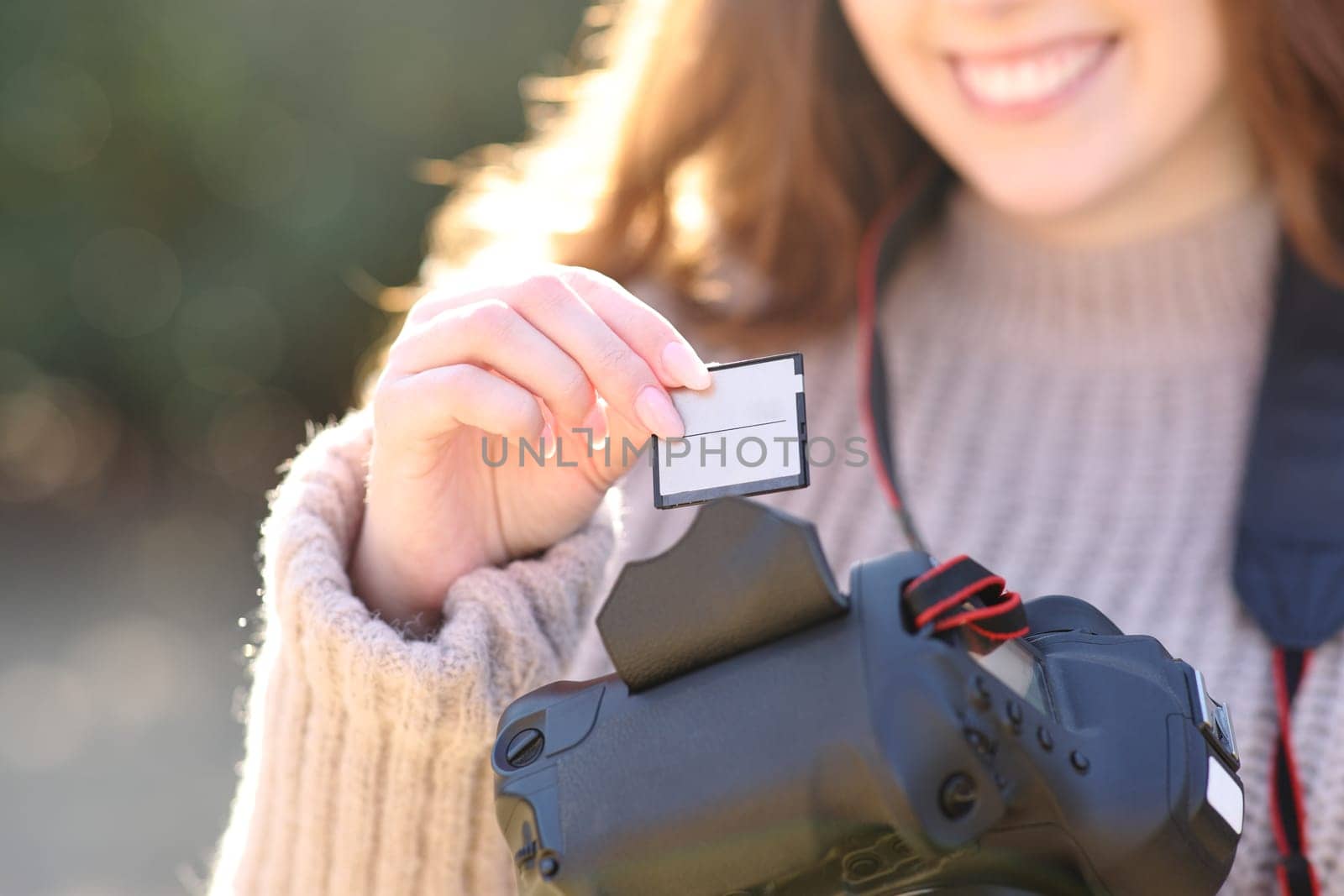Close up of a photographer inserting card on dslr camera in winter