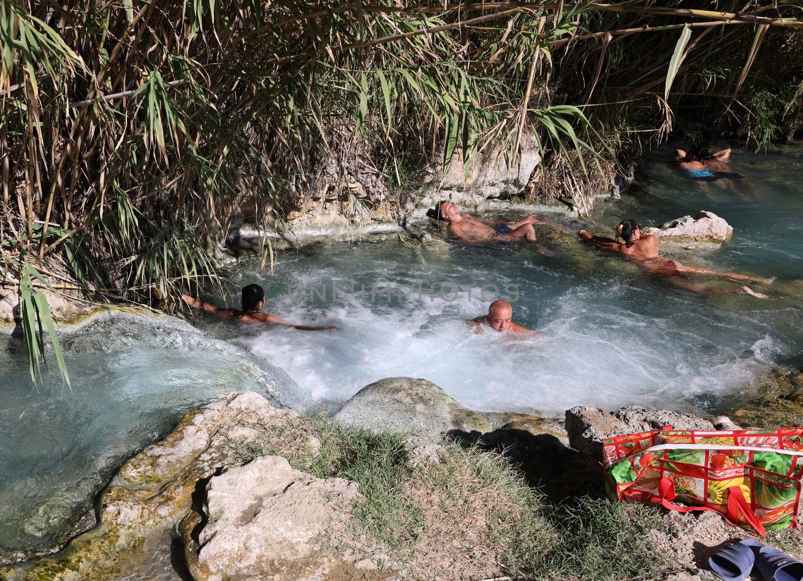 Saturnia, Italy - September 13, 2022:  People are bathing in the hot springs of Saturnia Therme, Saturnia, Tuscany, Italy