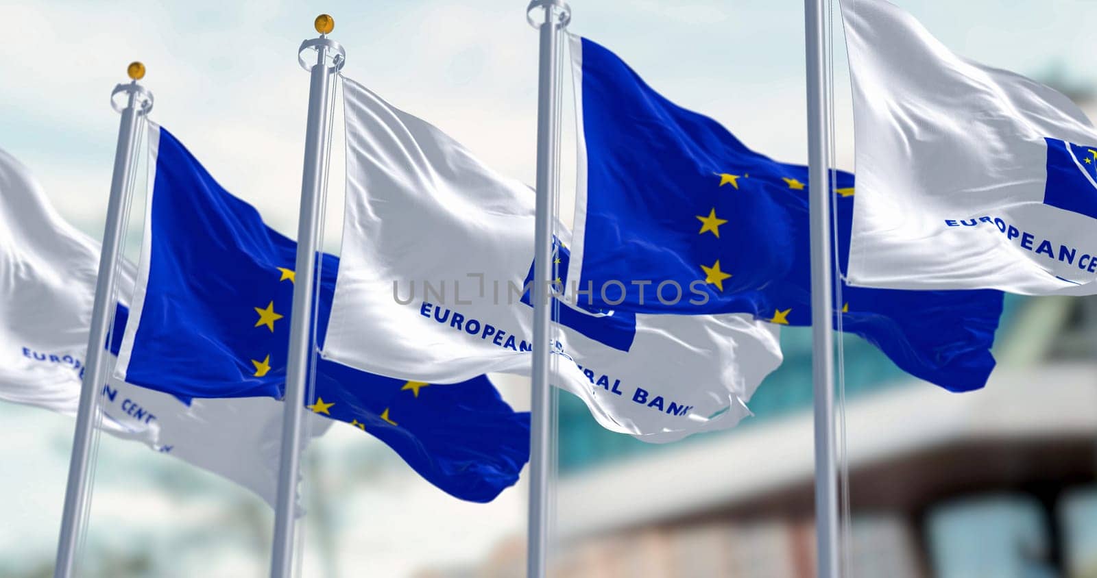 Frankfurt, DE, March 2023: Five Flags of the European Central Bank and European Union waving in the wind with the ECB seat blurred on background. Illustrative editorial 3d illustration render