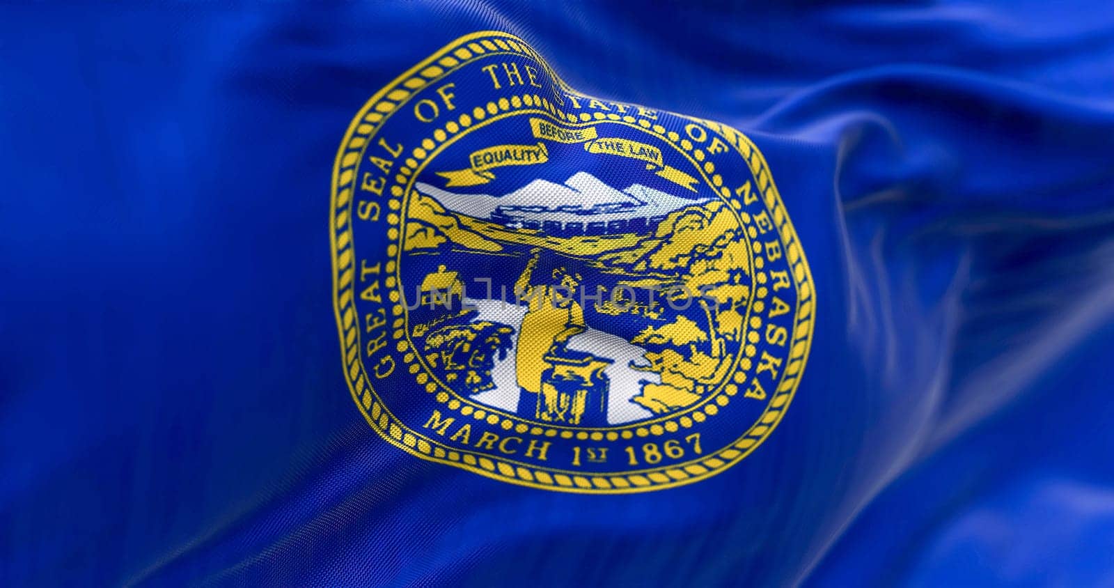 Close-up of the Nebraska state flag fluttering. The flag of is blue with the state seal in the center. 3D illustration render. Close-up. Textured textile background. Selective focus