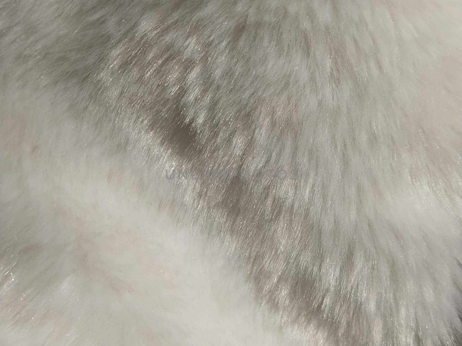 White faux fur. Close-up. Partially defocused photo. Fluffy villi.