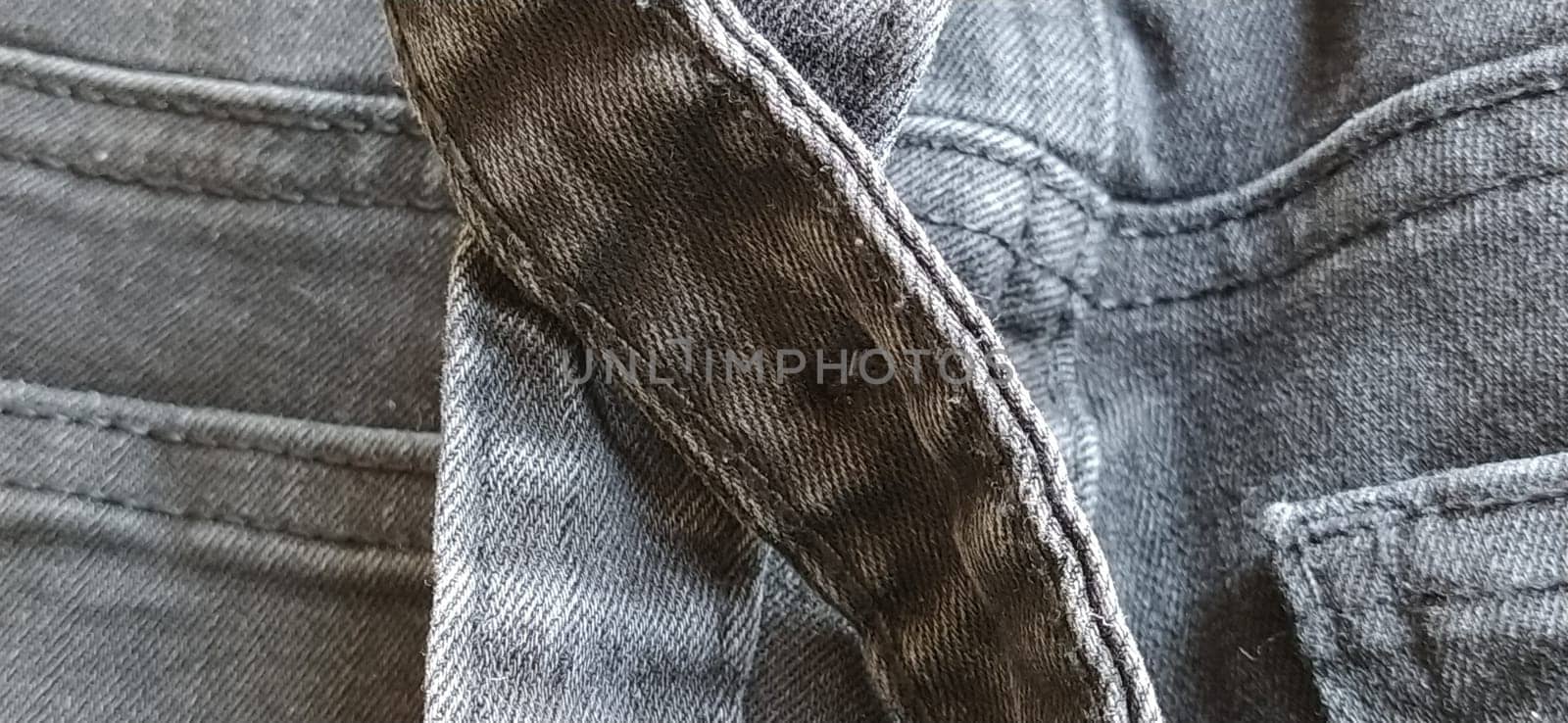 Fashionable denim clothing. Details and seams on rough denim. Black and white photography.