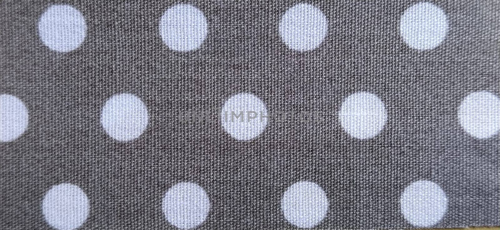 fabric white polka dots on a gray background, smoothed flat surface.