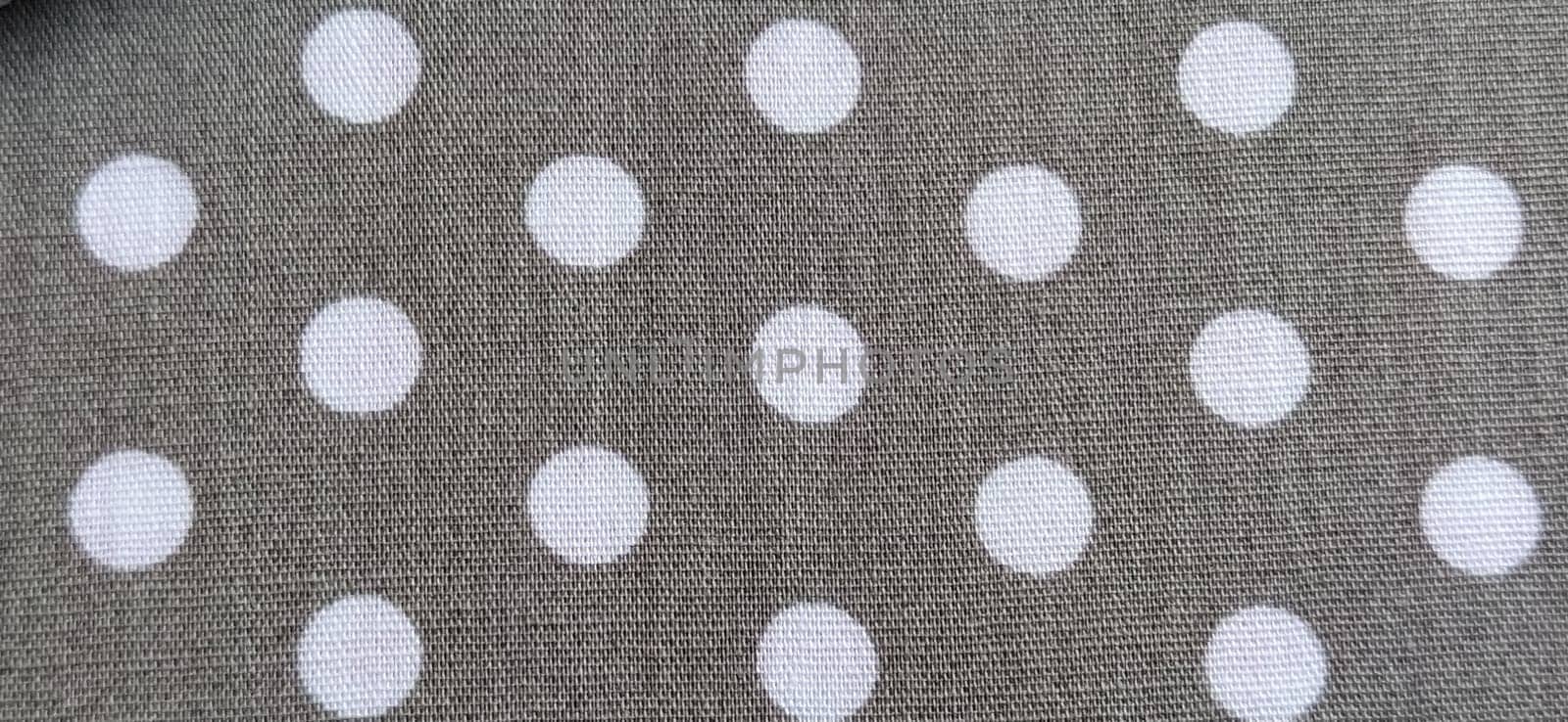 fabric white polka dots on a gray background, smoothed flat surface.