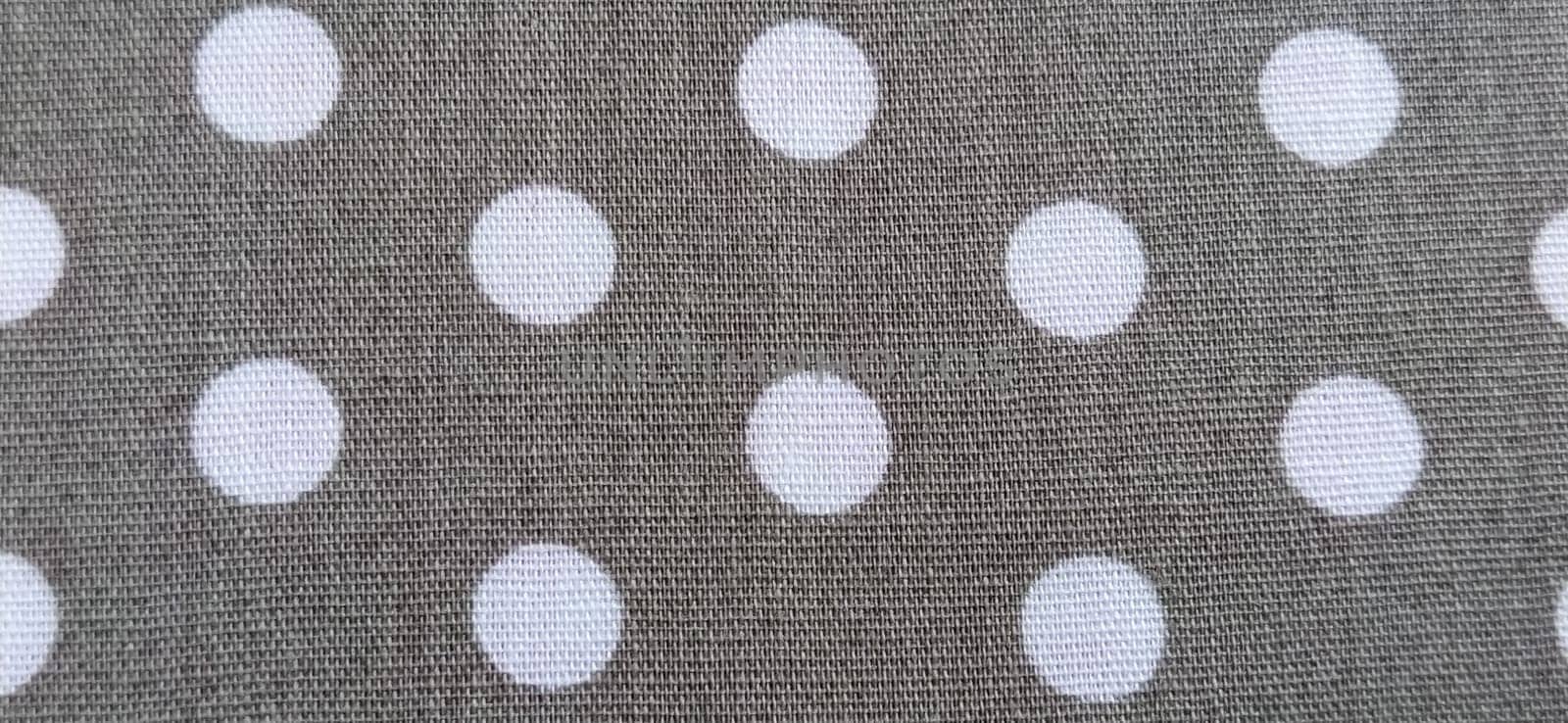 fabric white polka dots on a gray background, smoothed flat surface.