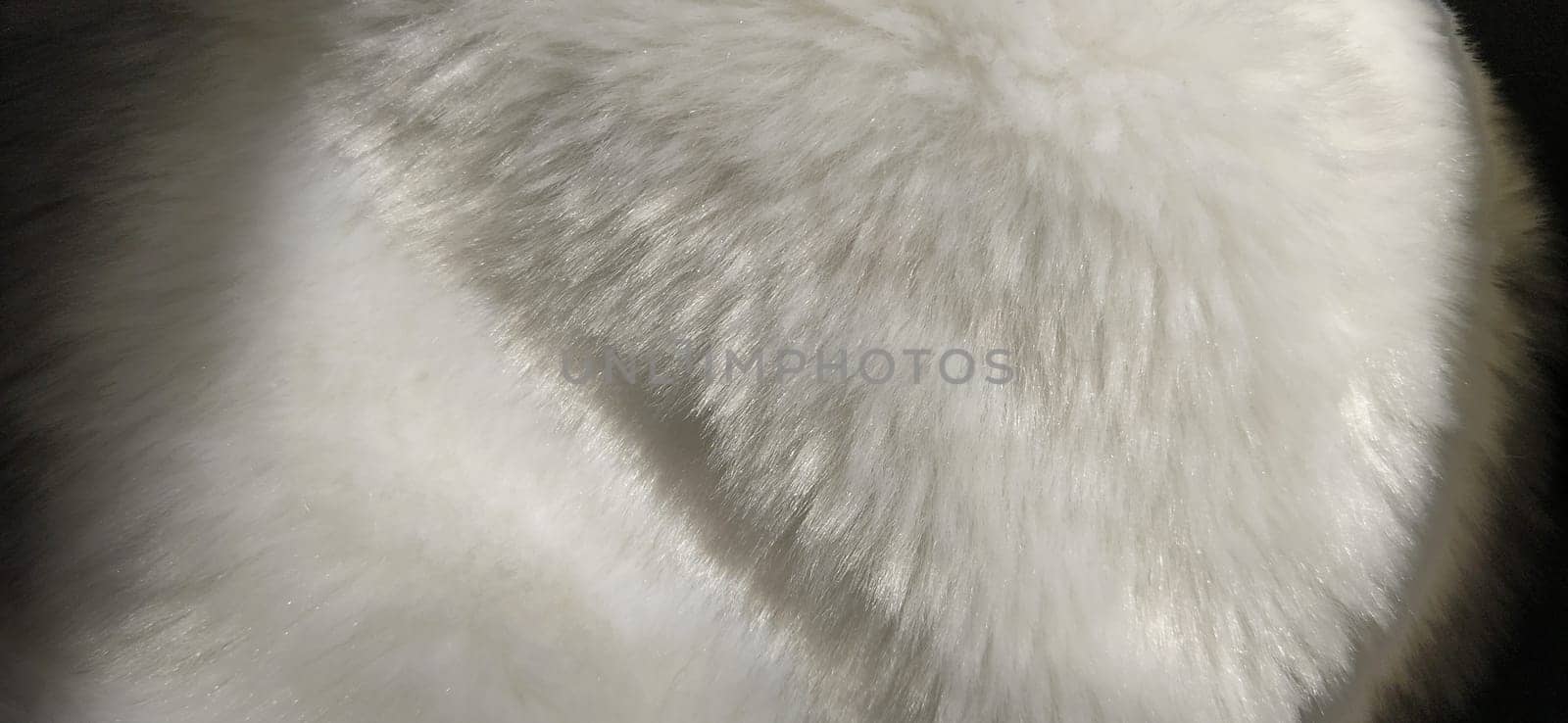 White faux fur. Close-up. Partially defocused photo. Fluffy villi.
