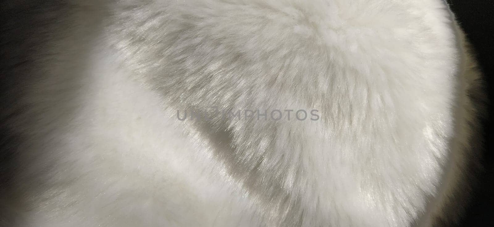 White faux fur. Close-up. Partially defocused photo. Fluffy villi.