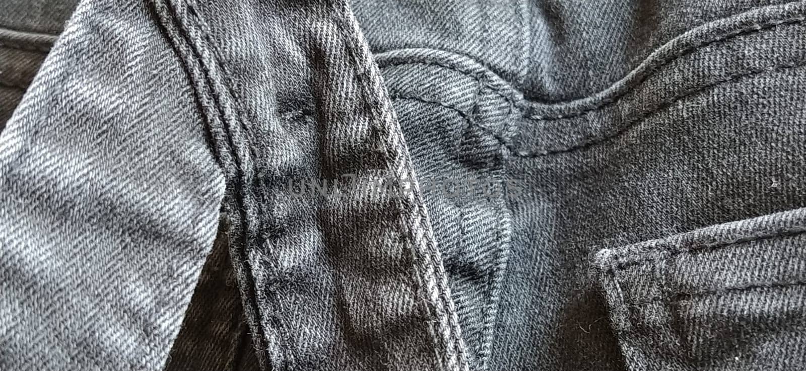 Fashionable denim clothing. Details and seams on rough denim. Black and white photography.
