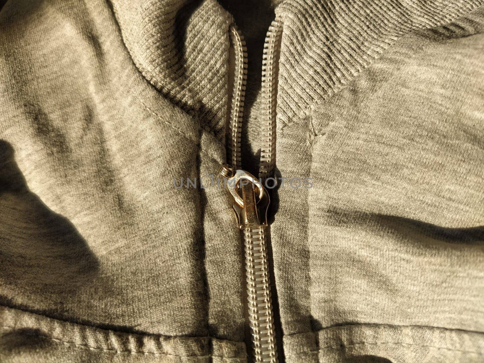 metal lock on gray long sleeve fabric. Tailoring.