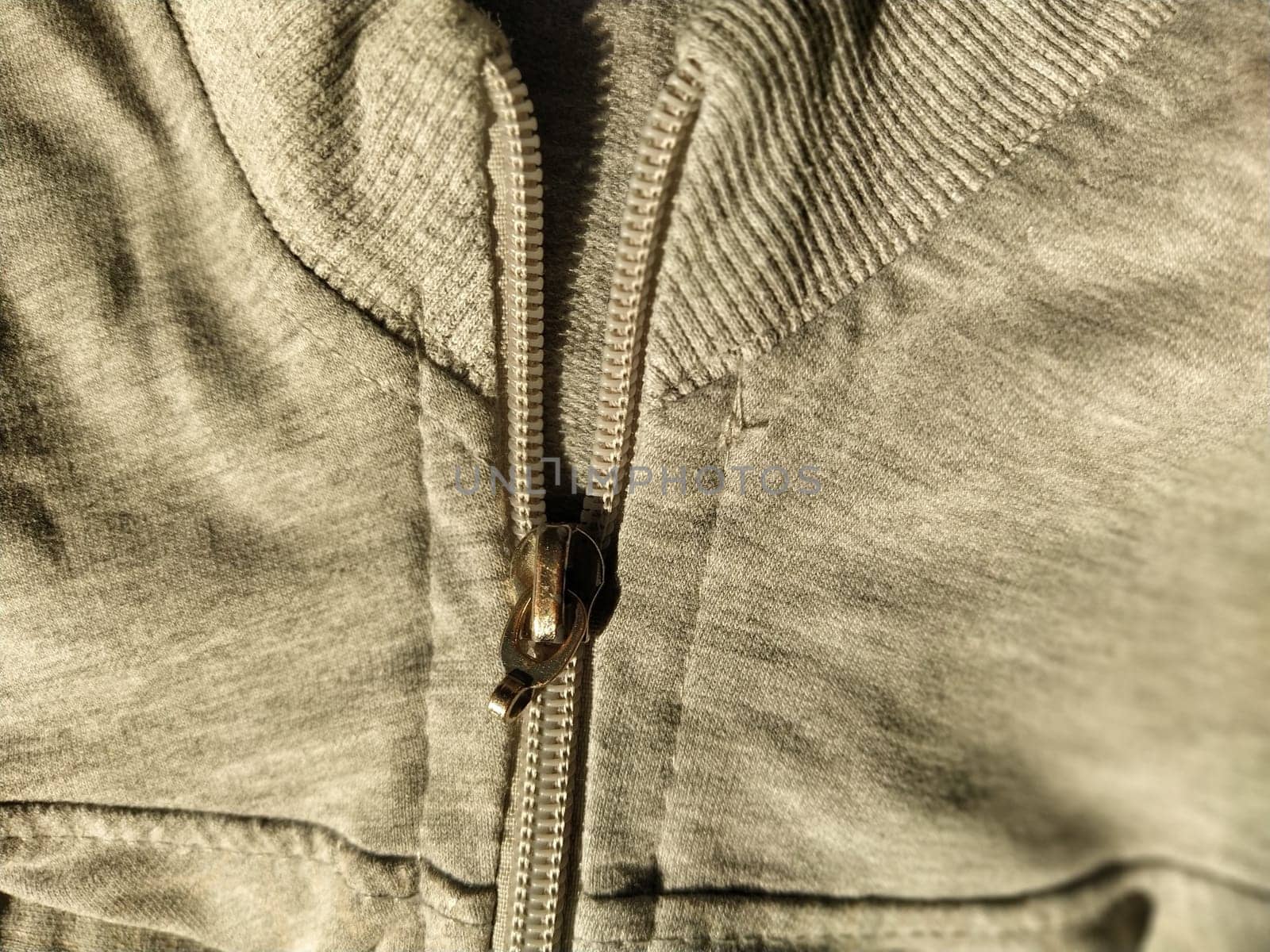 metal lock on gray long sleeve fabric. Tailoring.