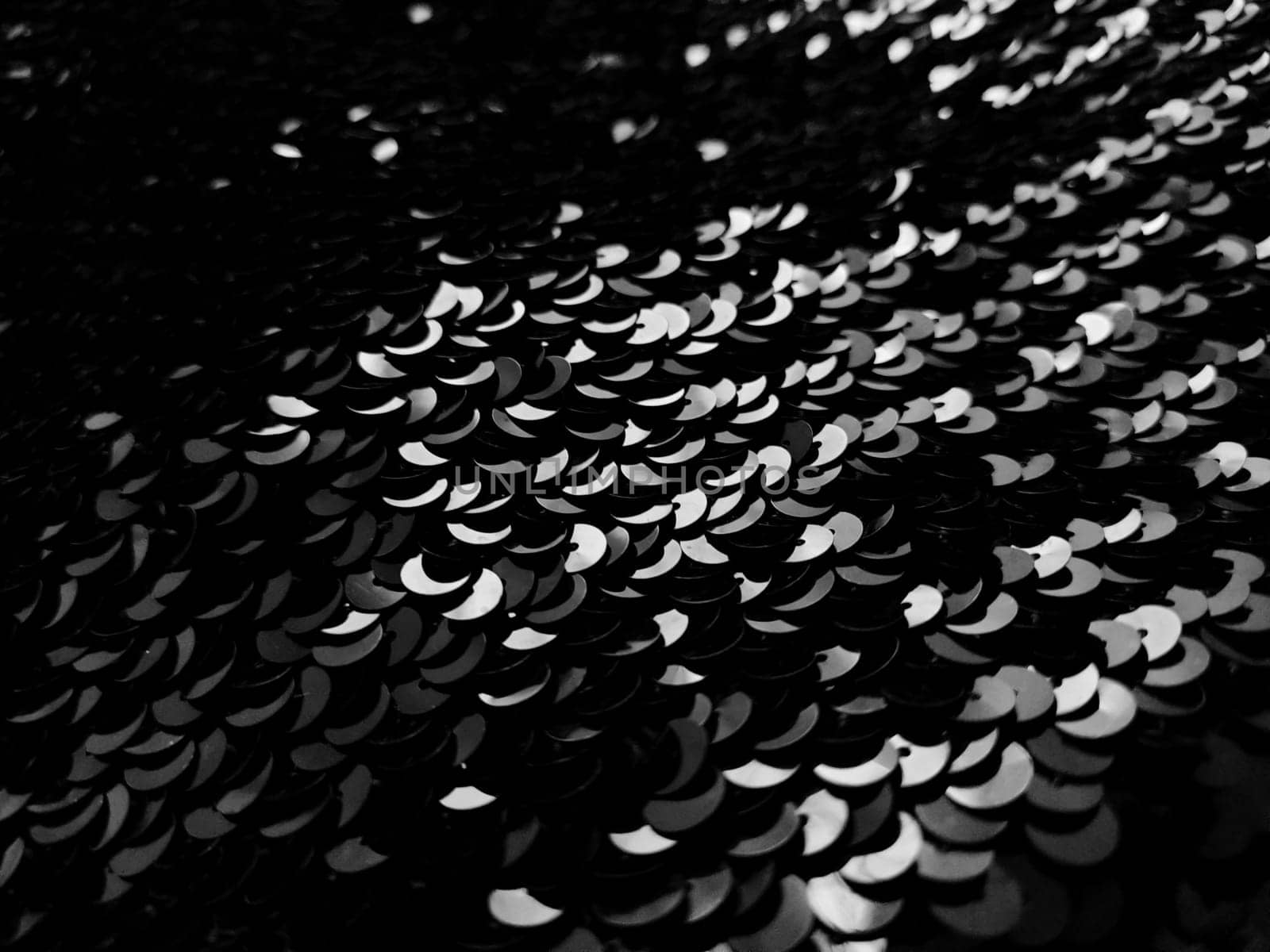 Beautiful abstract blurred background with black sequins. Gray and white elements on black.