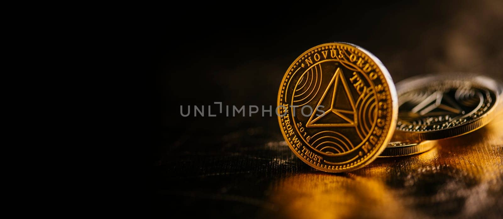 Closeup of golden tron coin TRX cryptocurrency over black and gold background. Virtual money altcoin and blockchain concept.