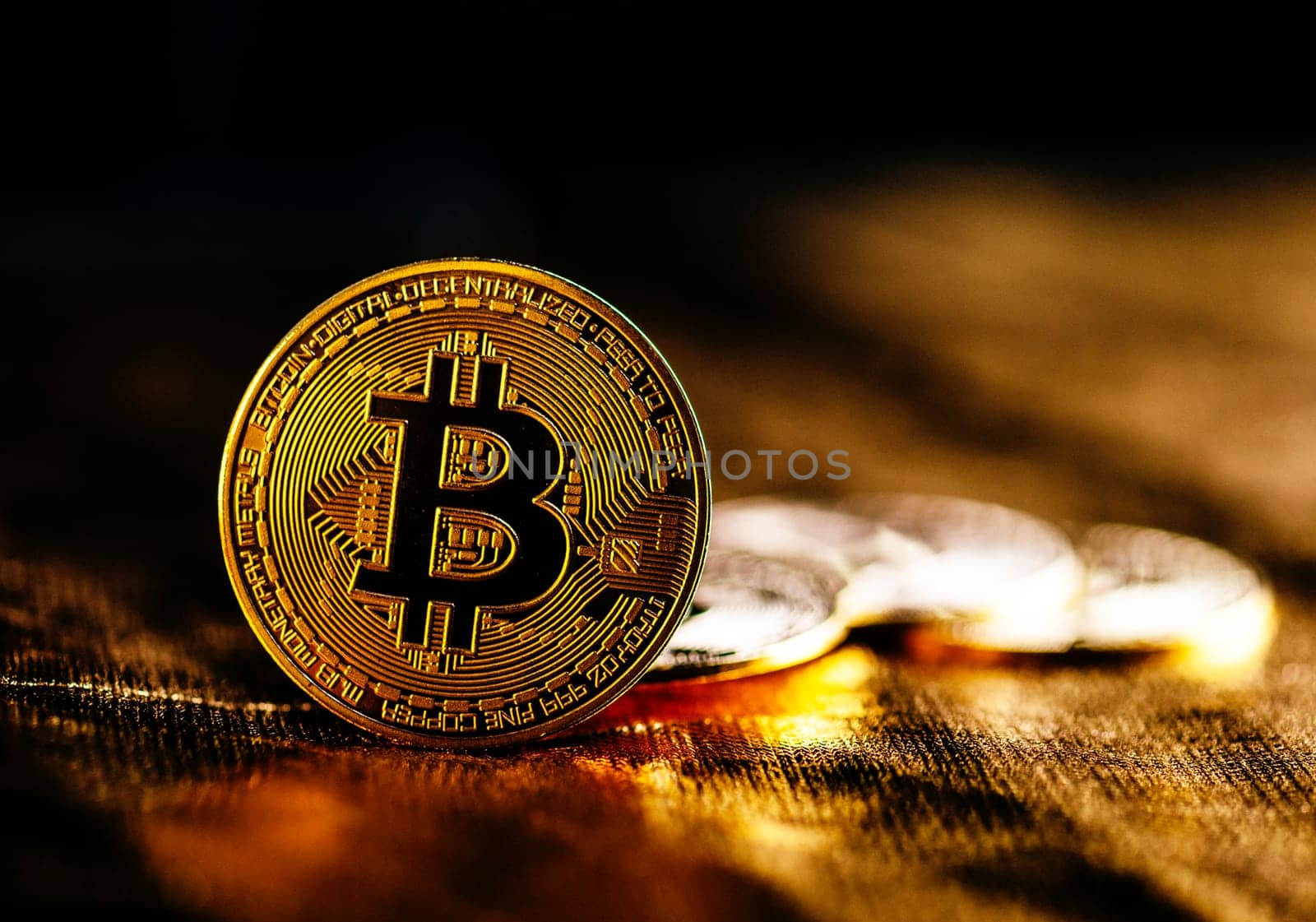 Closeup of golden bitcoin BTC cryptocurrency over black and gold background. Virtual money and blockchain concept.