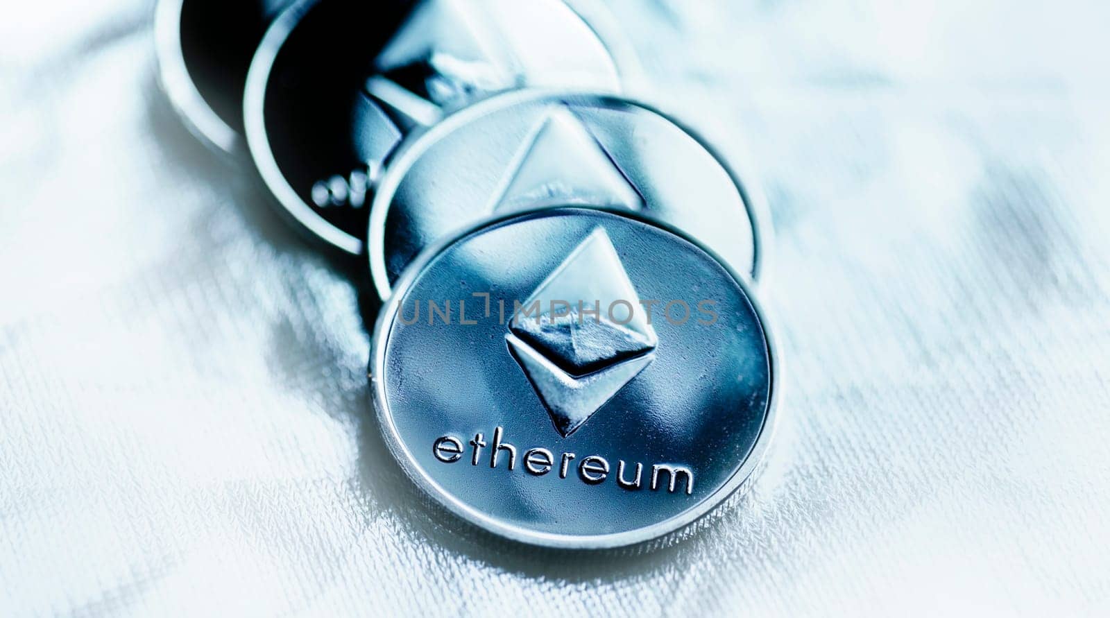 Closeup of ethereum coin cryptocurrency over silver background. Blockchain, virtual money and crypto mining concept.