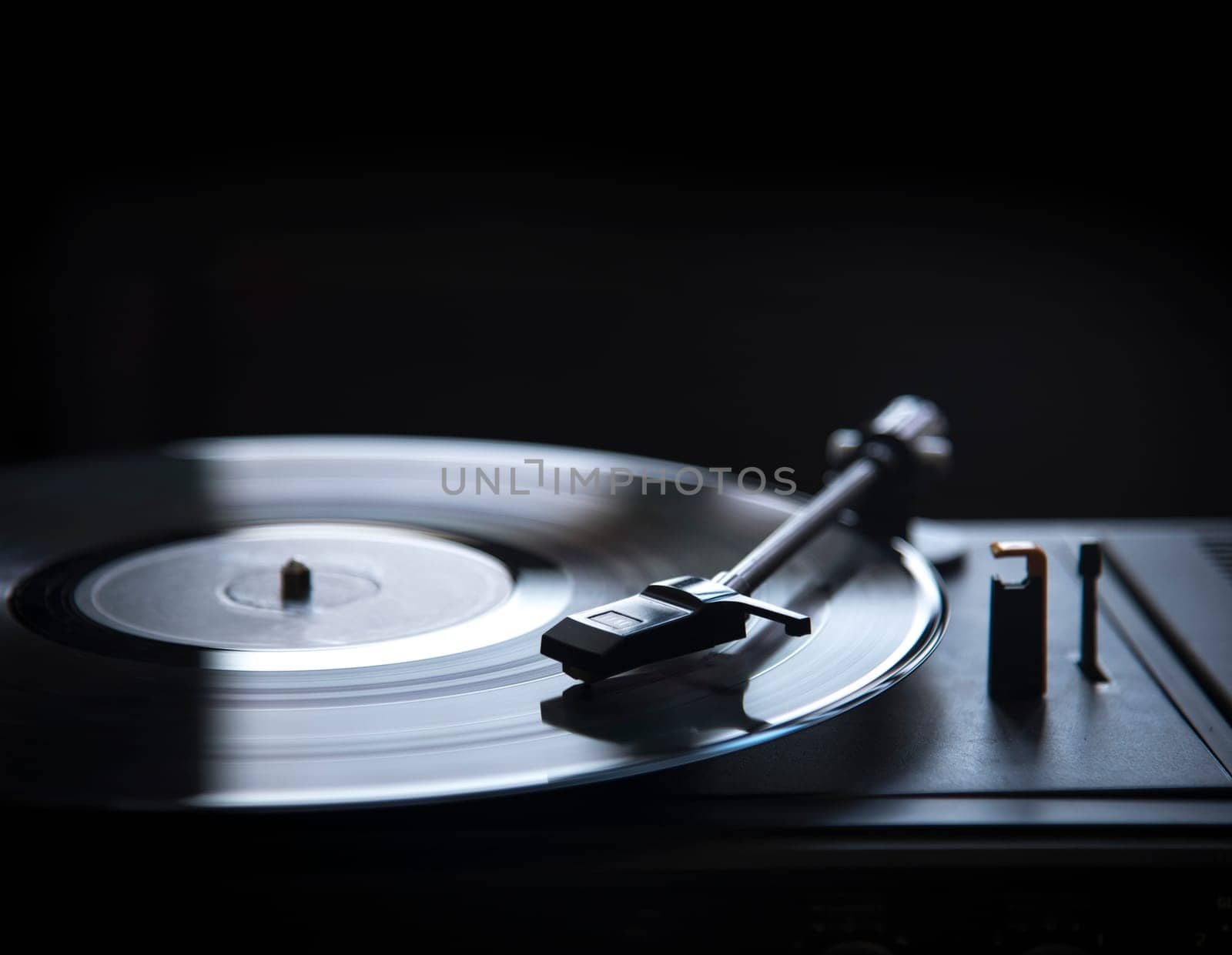 Retro gramophone vinyl player over black background with copyspace. Dj music and soundtrack album design.