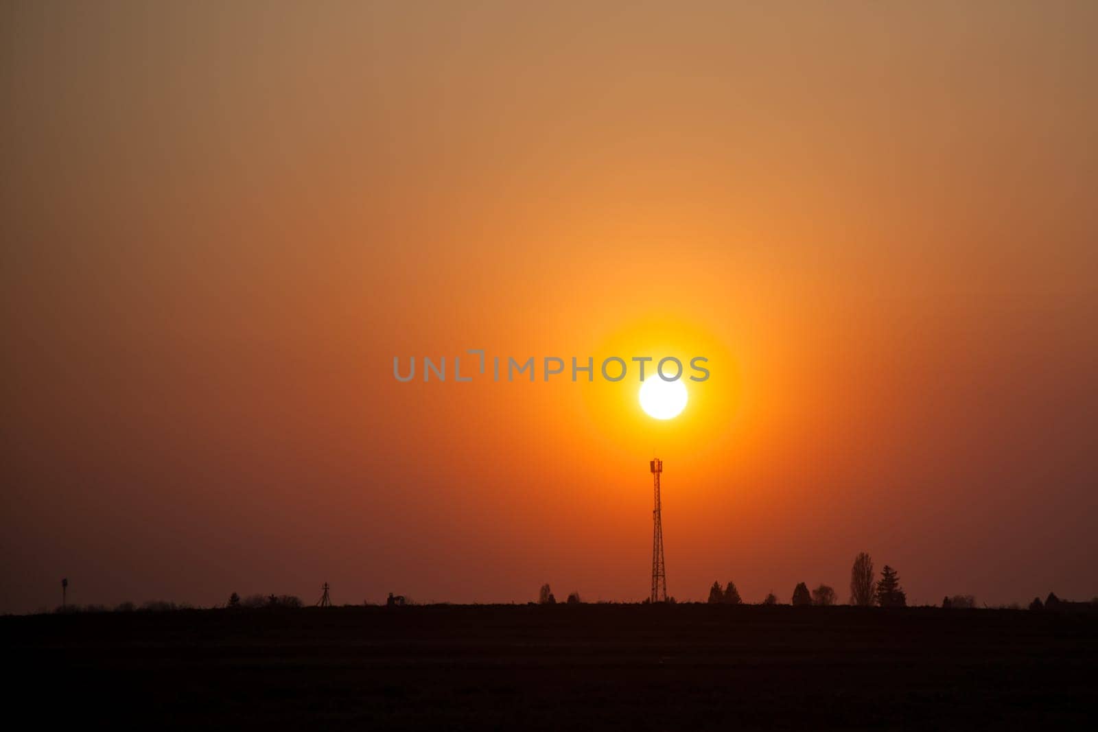 Red sunset over the field. Beautiful sunset in nature. Rural nature at sunset. Red sunset landscape