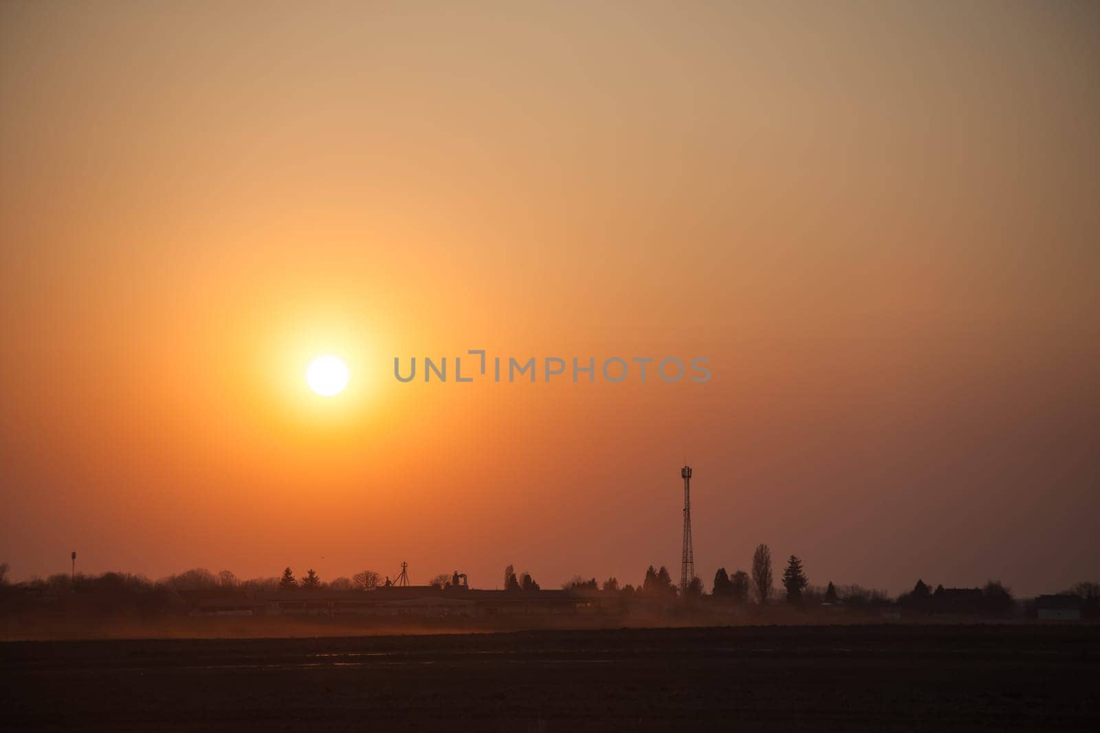 Red sunset over the field. Beautiful sunset in nature. Rural nature at sunset. Red sunset landscape