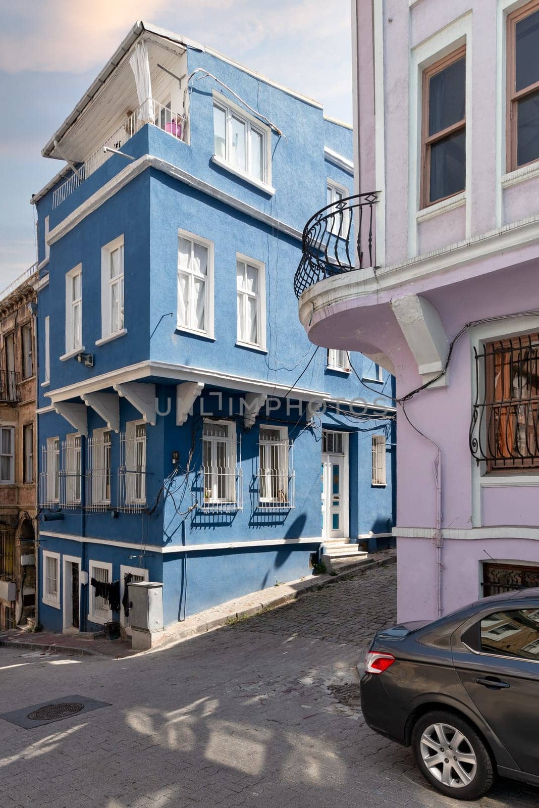 Cobblestone alley with beautiful old traditional blue painted house in old Balat district, on a summer day, Istanbul, Turkey
