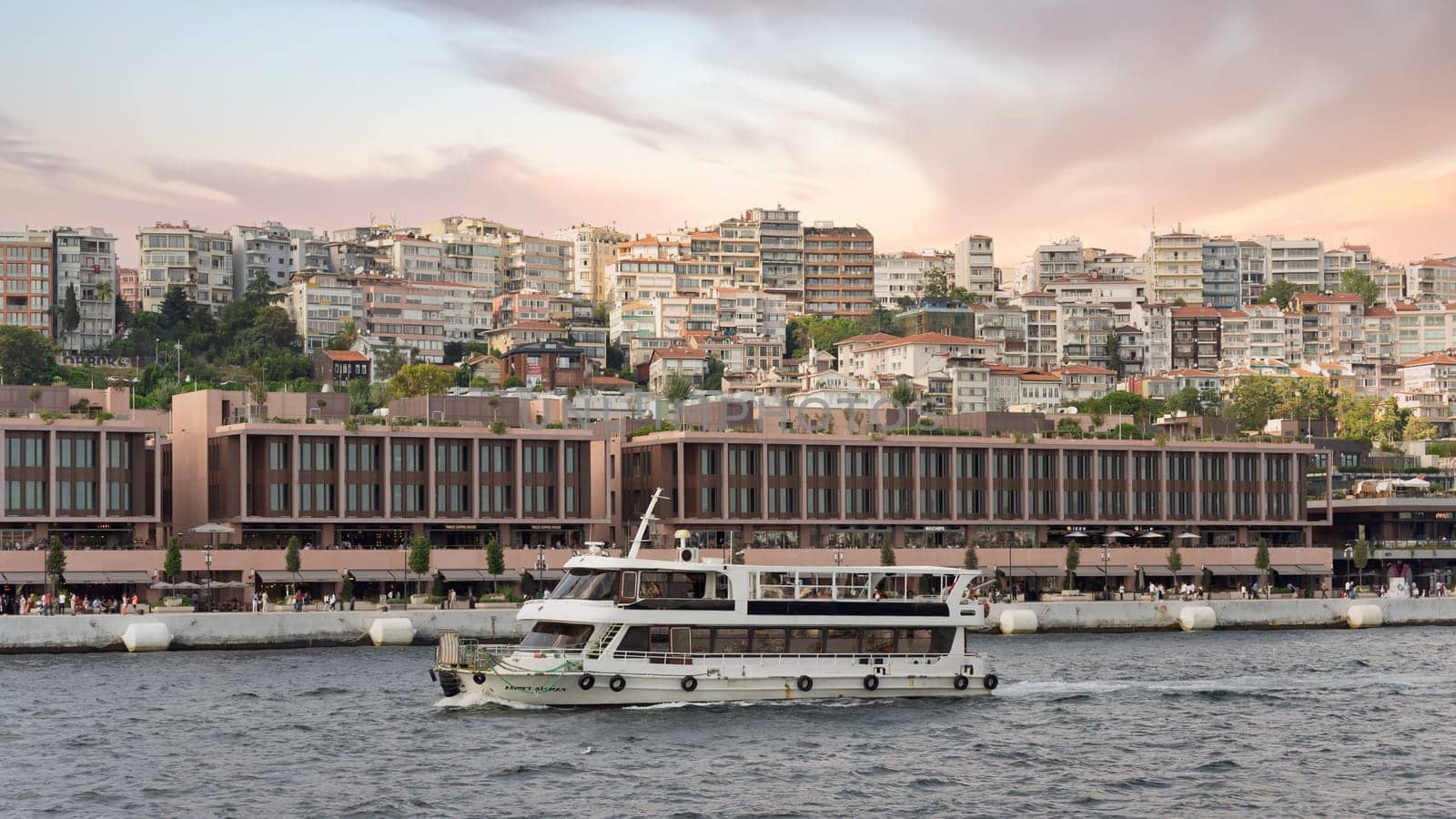 Istanbul, Turkey - September 1, 2022: Ferry boat sailing in Bosphorus Strait in front of Galataport, a mixed use development located in Karakoy neighbourhood