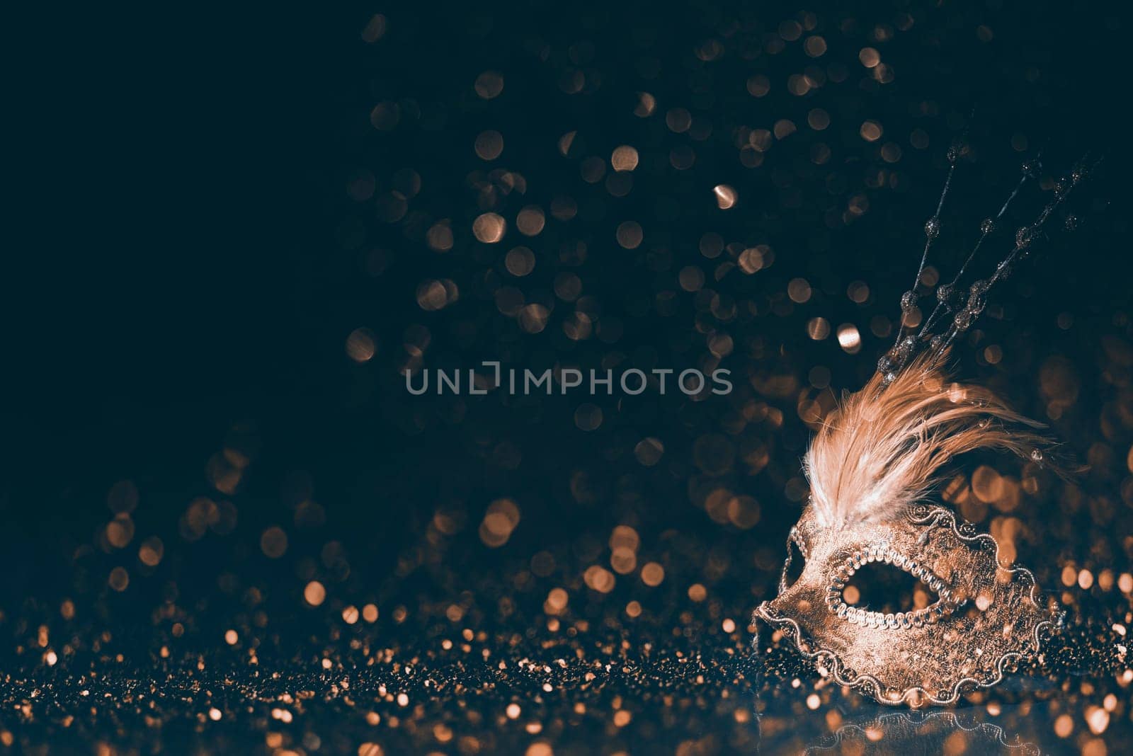 Luxury venetian mask on dark godlen bokeh background. New year and christmas party celebration design banner. Carnival masquerade fantasy costume ball.