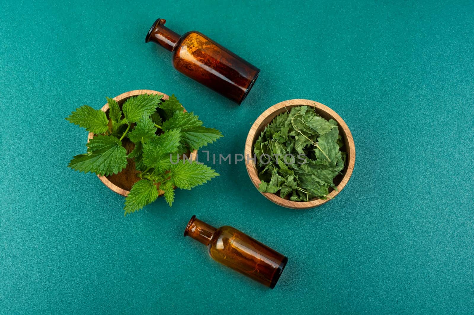 Fresh and dried nettle leaves, homeopathic herbs on a wooden table. Herbal medicine