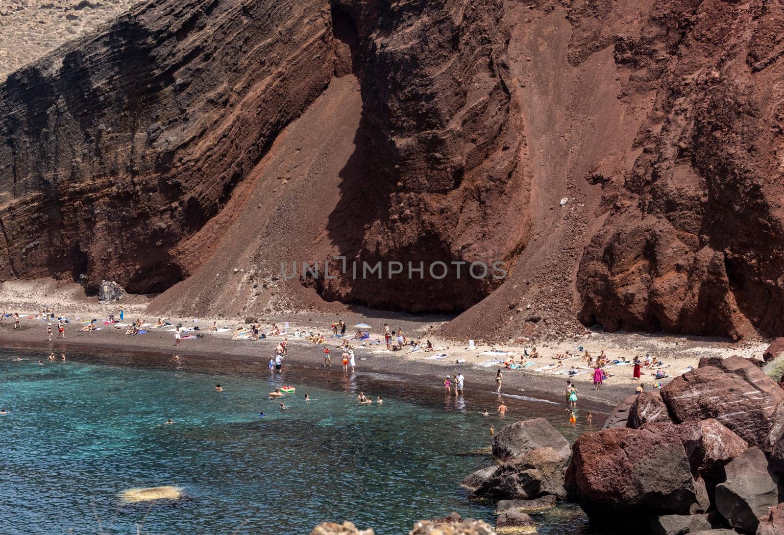 Santorini, Greece - July 01, 2021: The famous Red beach on the south coast of Santorini island, Cyclades, Aegean Sea.