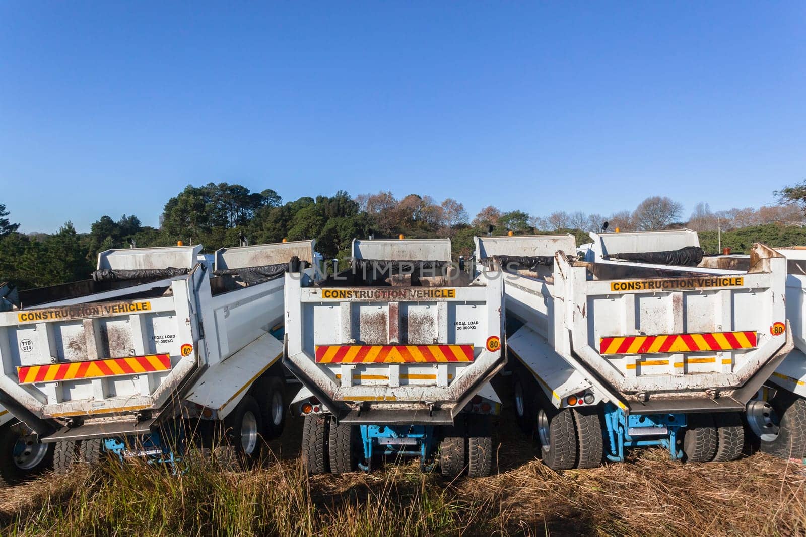 Construction Truck vehicles parked roadside  used for  new asphalt tar surfacing maintenance on car highways.