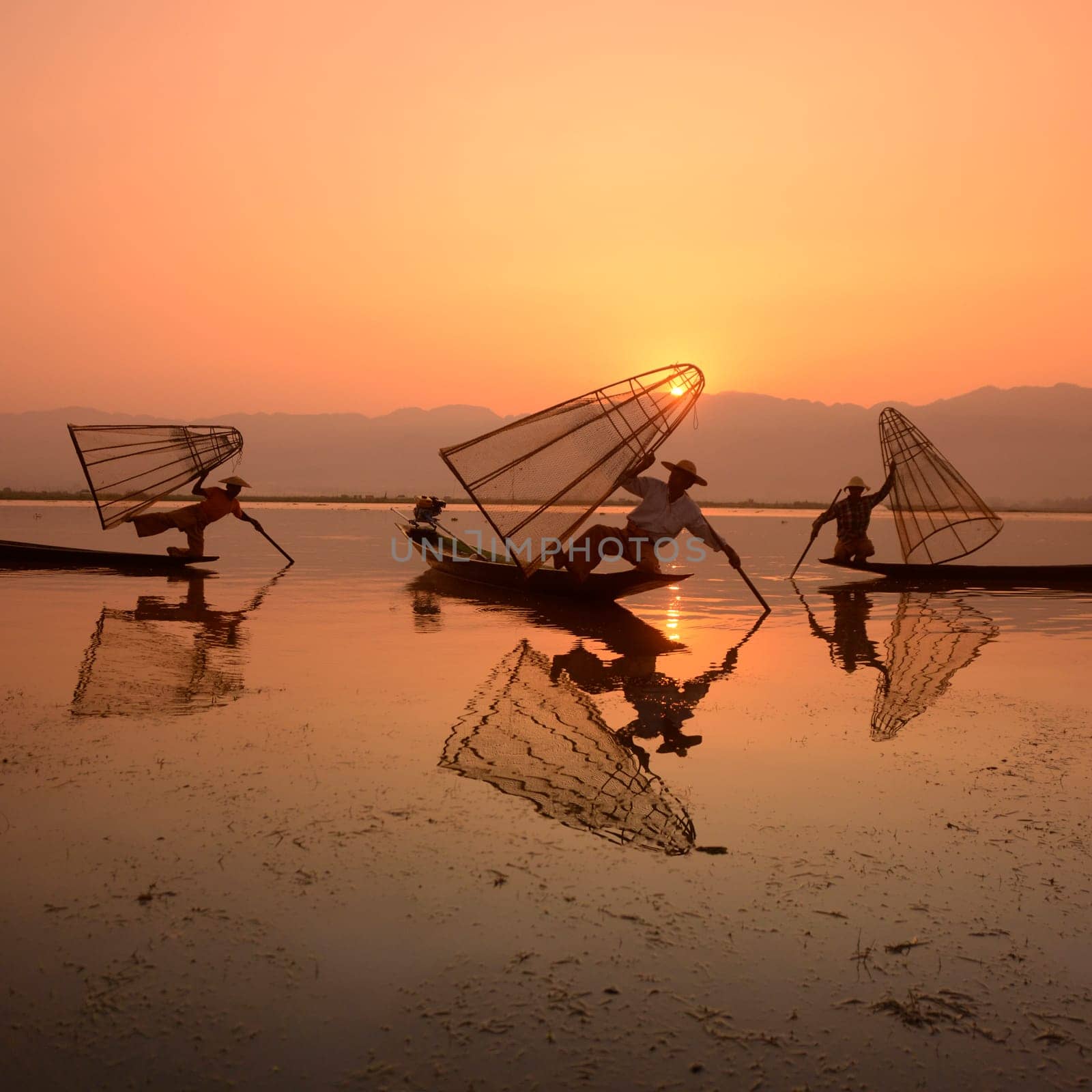 Fishermen at sunrise in the Landscape on the Inle Lake in the Shan State in the east of Myanmar in Southeastasia.
