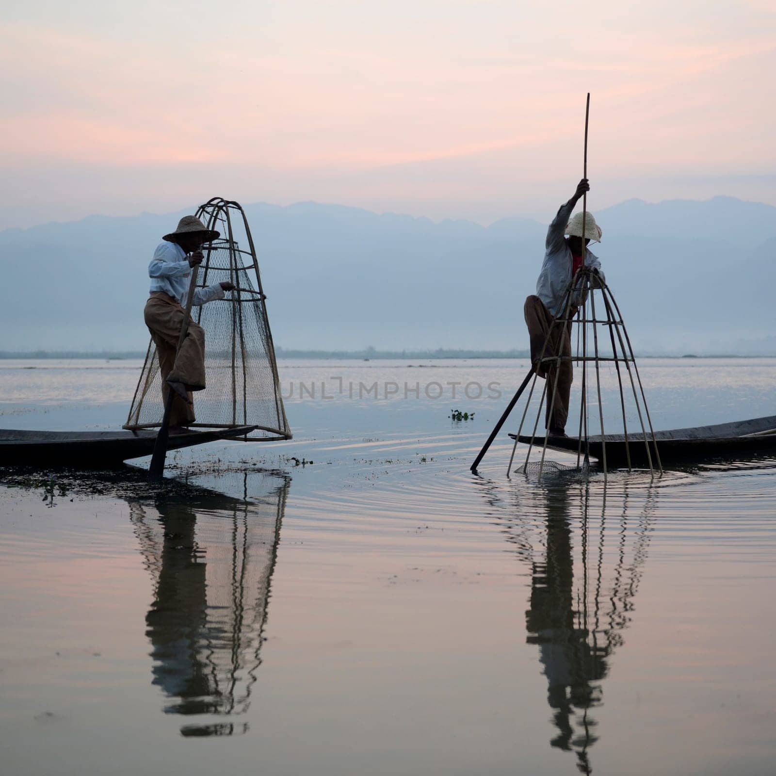 Fishermen at sunrise in the Landscape on the Inle Lake in the Shan State in the east of Myanmar in Southeastasia.