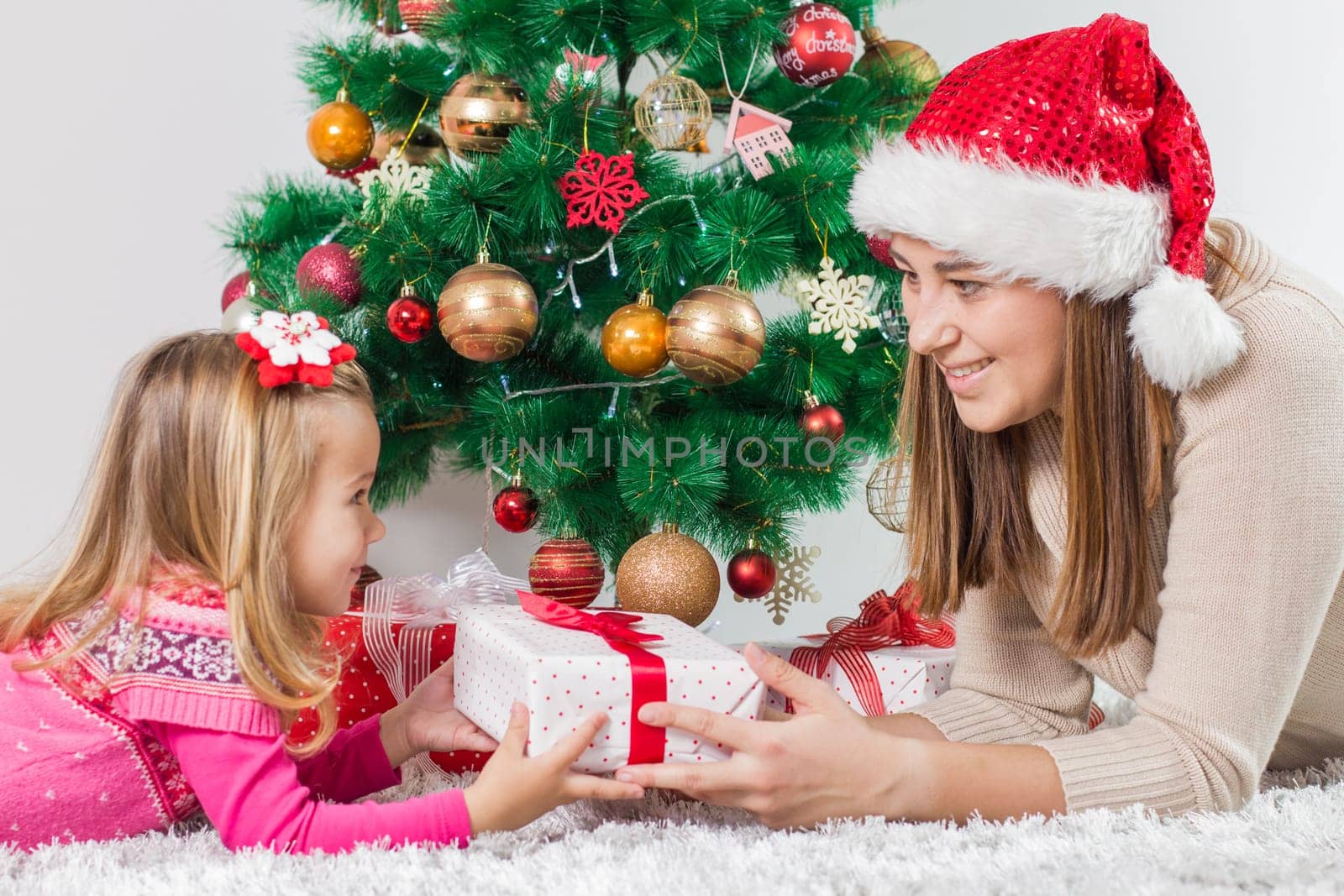Christmas Happy Family mother and her little daughter open Holidays Gift.