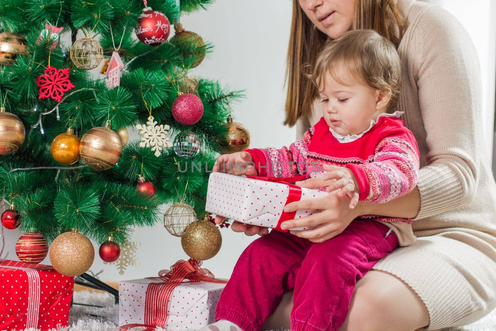 Christmas Happy Family mother and her little daughter open Holidays Gift.