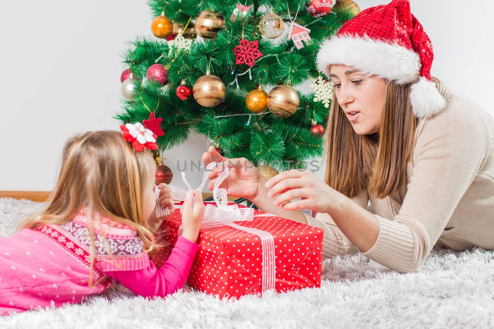 Christmas Happy Family mother and her little daughter open Holidays Gift.