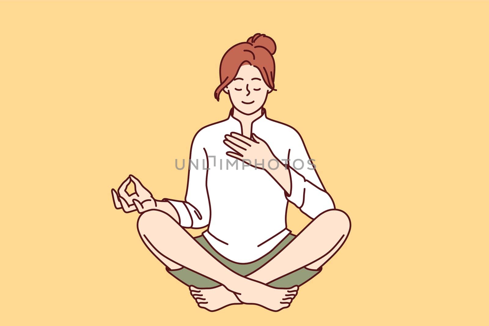 Woman meditates with hand on heart and wishes to heal herself through yoga and Buddhist spiritual practices. Girl sitting in lotus position takes care of heart chakra and relaxes during yoga