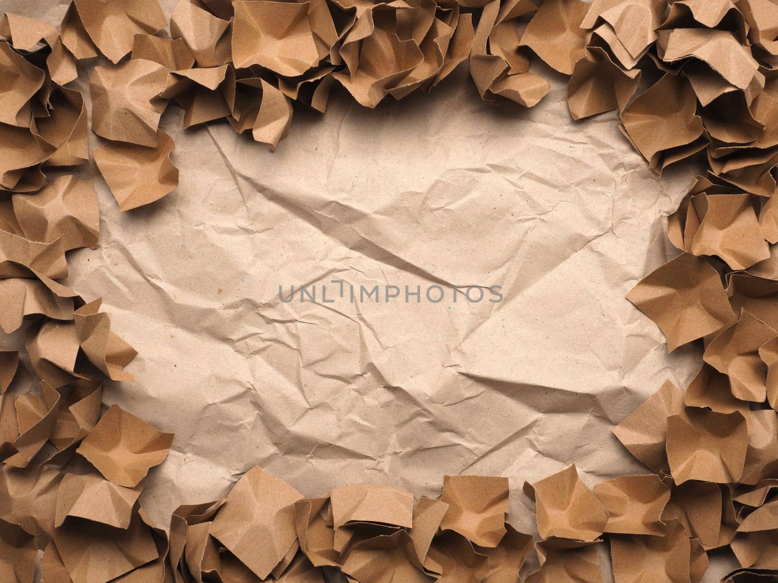 Border or frame made from recycled paper packaging material on a crushed recycled paper background with space for your text