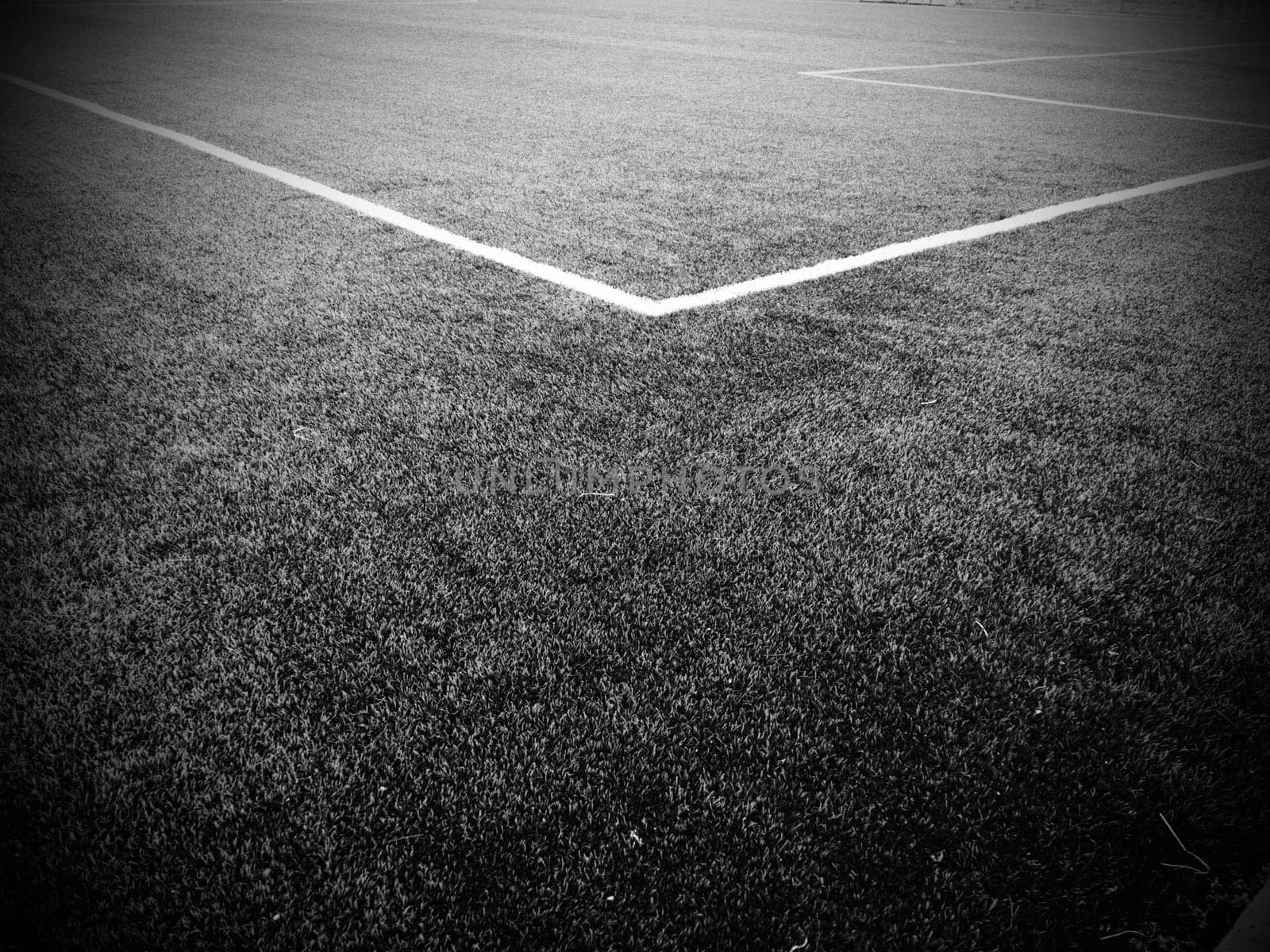The marking of the football field. White lines no more than 12 cm or 5 inches wide. Football field area. Black and white monochrome photography.