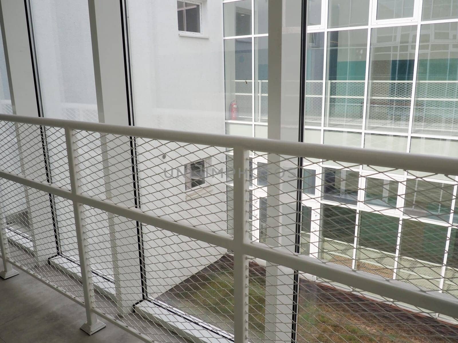 New white frames and windows. Metal fence for the safety of schoolchildren. New modern school. View from the window to the opposite wall and windows. Security systems. Internal office interior