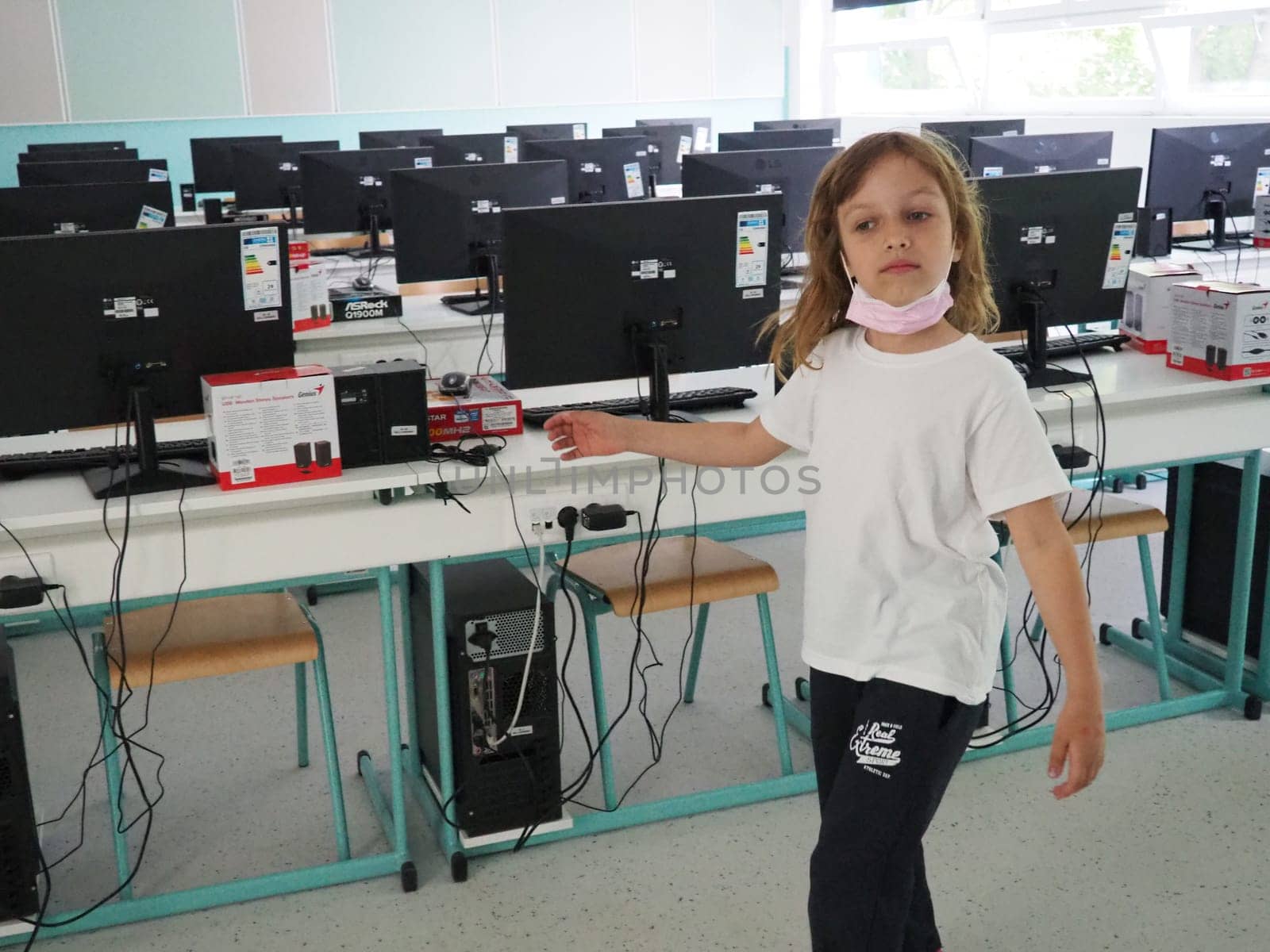 Sremska Mitrovica, Serbia, May 15, 2021 Group of computer neatly placed in a computer lab. Computers, monitors, wires in the modern classroom of the new school. School desks for pupils and students.