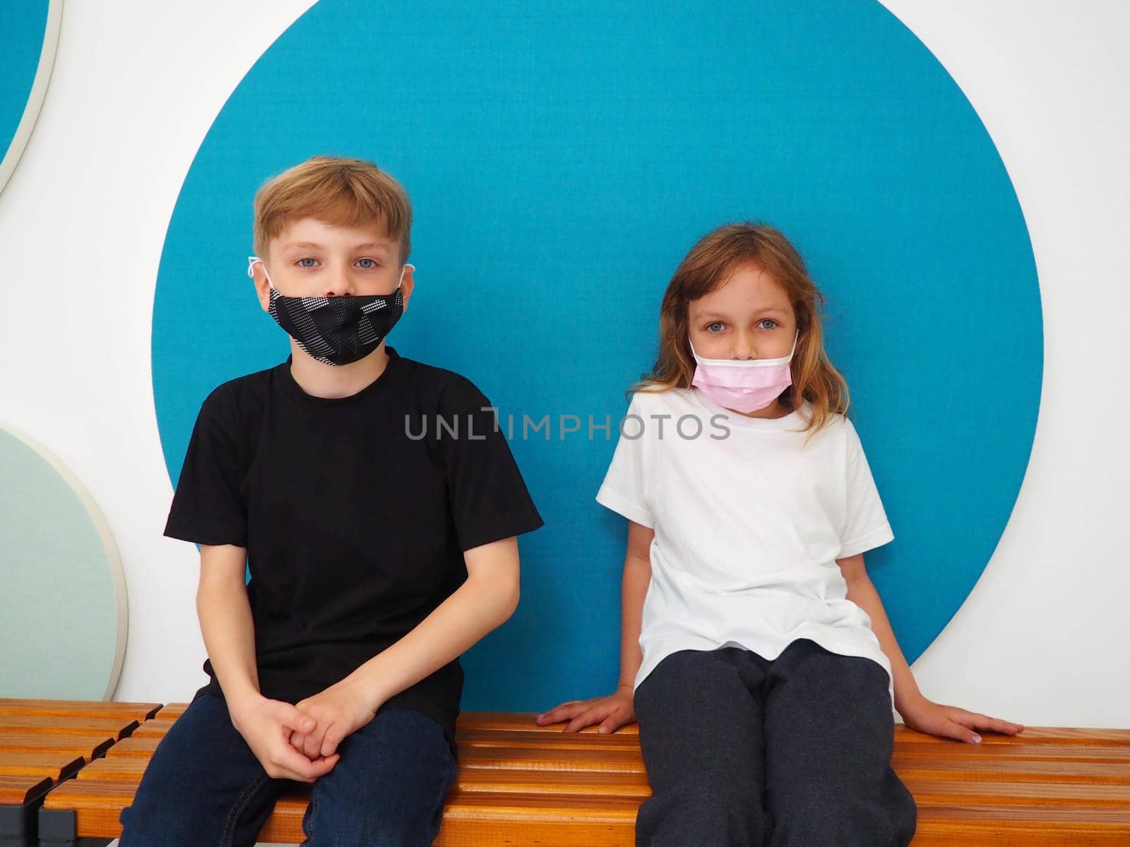 School children wearing face mask during corona virus and flu outbreak. Boy and girl going back to school after covid-19 quarantine and lockdown. Group of kids in masks for coronavirus prevention