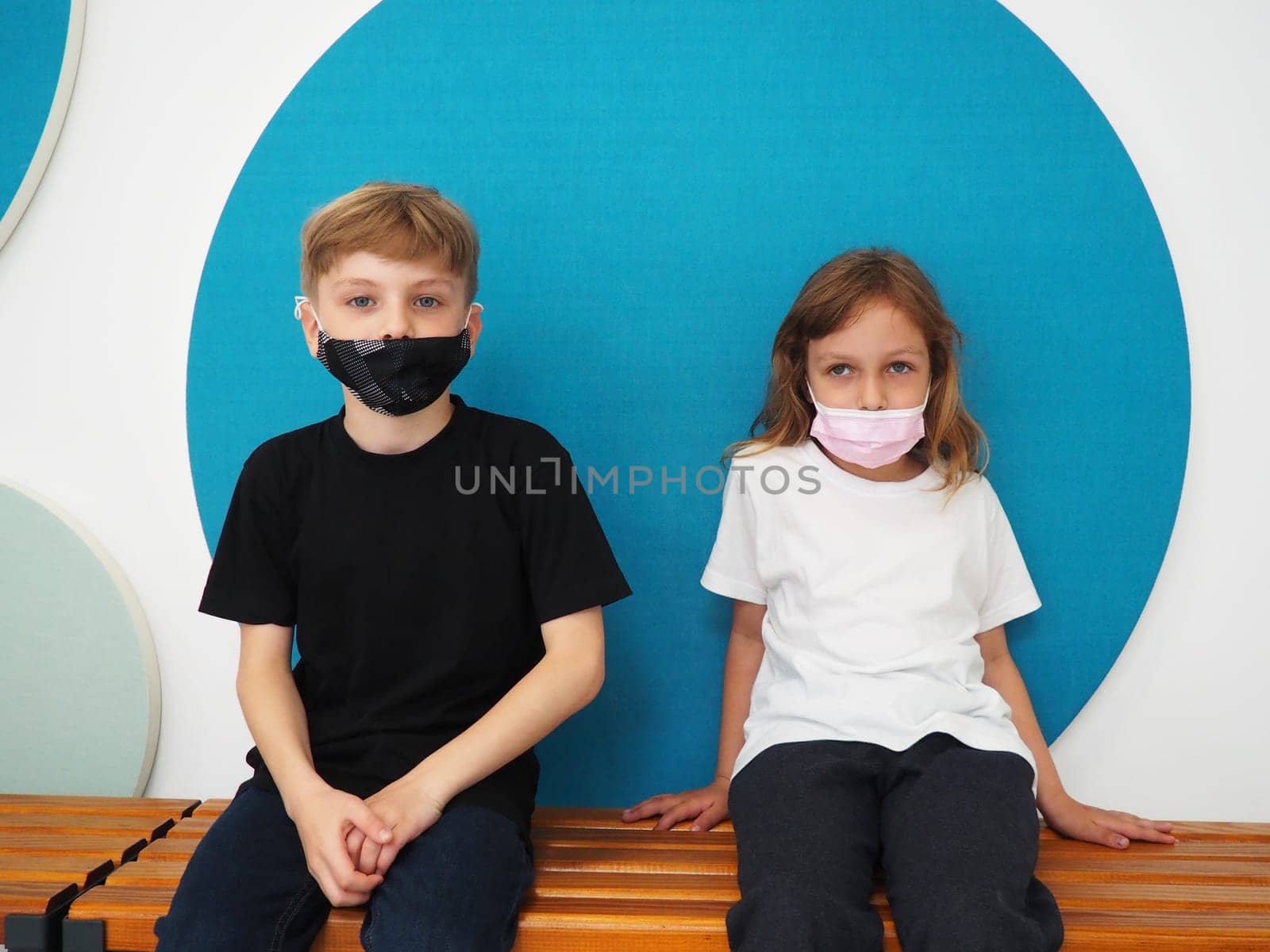 School children wearing face mask during corona virus and flu outbreak. Boy and girl going back to school after covid-19 quarantine and lockdown. Group of kids in masks for coronavirus prevention