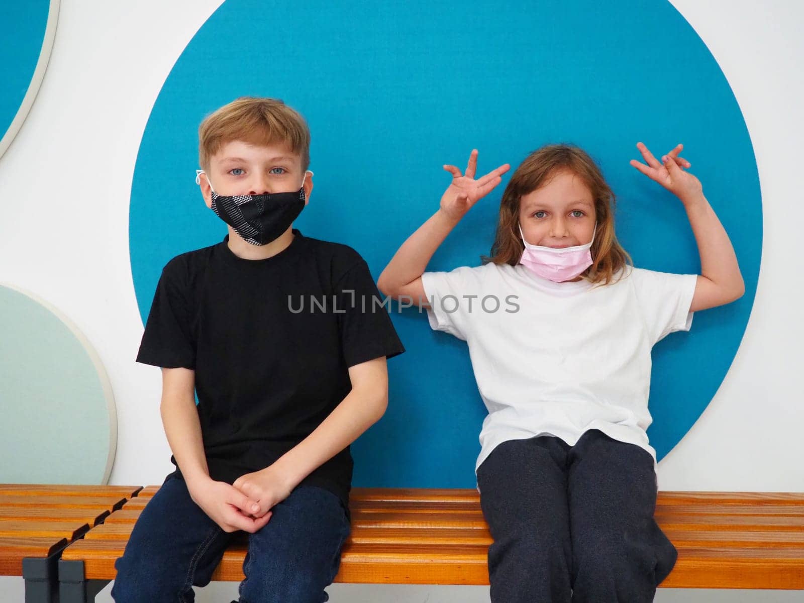 School child wearing face mask during corona virus and flu outbreak. Boy and girl going back to school after covid-19 quarantine and lockdown. Group of kids in masks for coronavirus prevention.