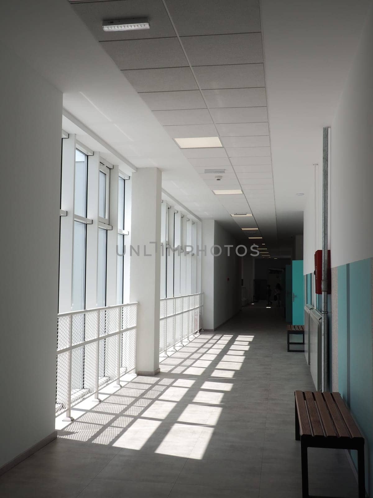 Sremska Mitrovica, Serbia, May 15, 2021. school corridor in a new modern school. White interior of the foyer. High ceilings, large plastic white windows. The sun's rays fall into the room.