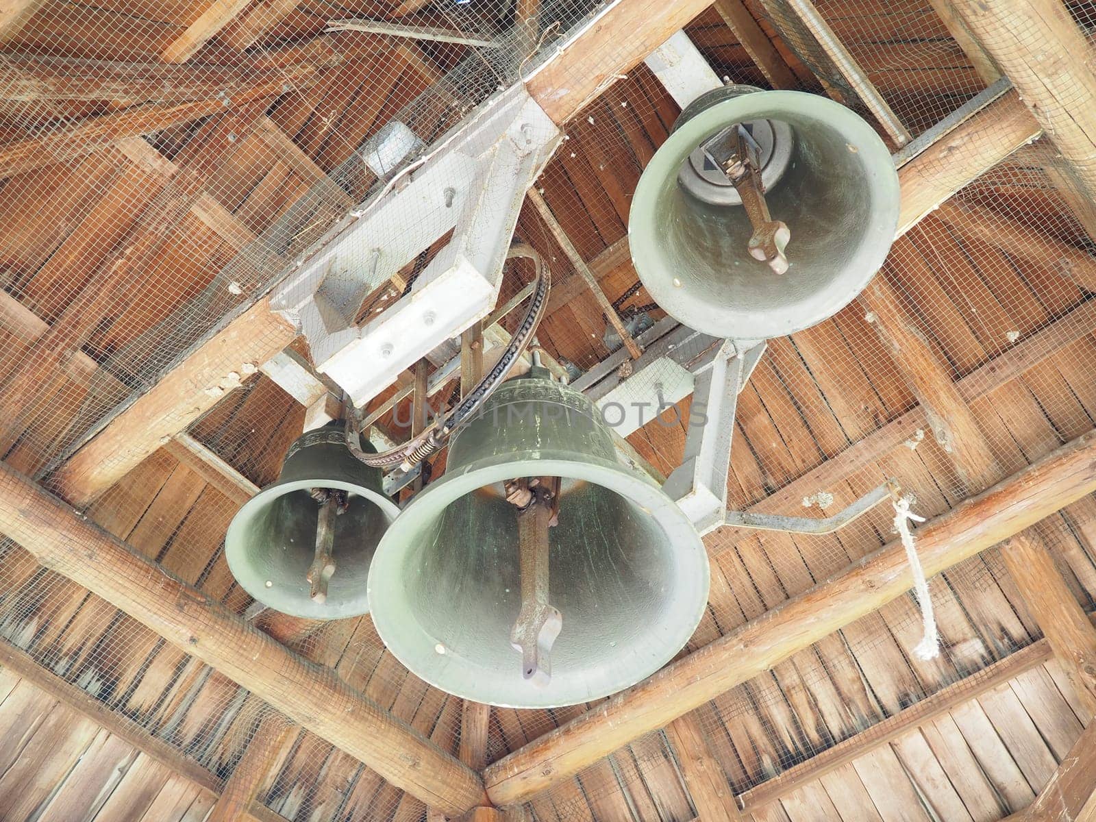 Old grunge bell. Bells in the bell tower. Large metal bells under a wooden roof. Stanisici, Bijelina, Republika Srpska, Bosnia and Herzegovina. Religious buildings for ceremonies.