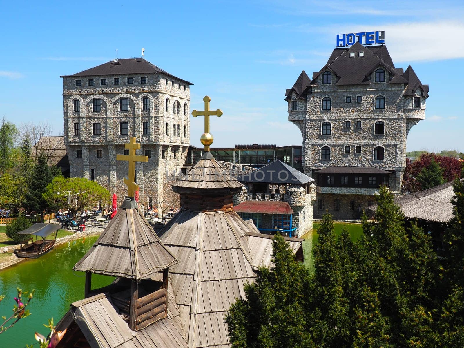 Stanisici, Bijelina, Republika Srpska, Bosnia and Herzegovina April 25 2021 Ethno village, tourism and attractions. Stone and wooden buildings of the hotel. People visit restaurant, traditional houses