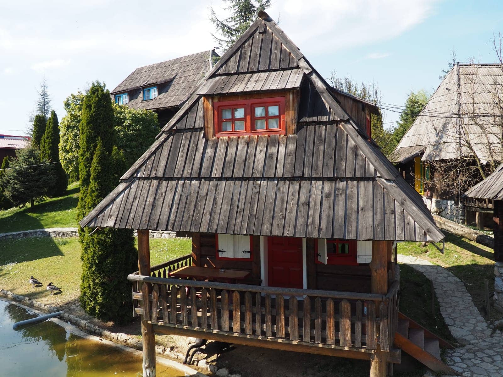 Stanisici, Bijelina, Bosnia and Herzegovina, 25 April 2021. Log village farmhouse. 19th century Bosnian mountain traditional dwelling. Restored ethno building, implements of agricultural labor