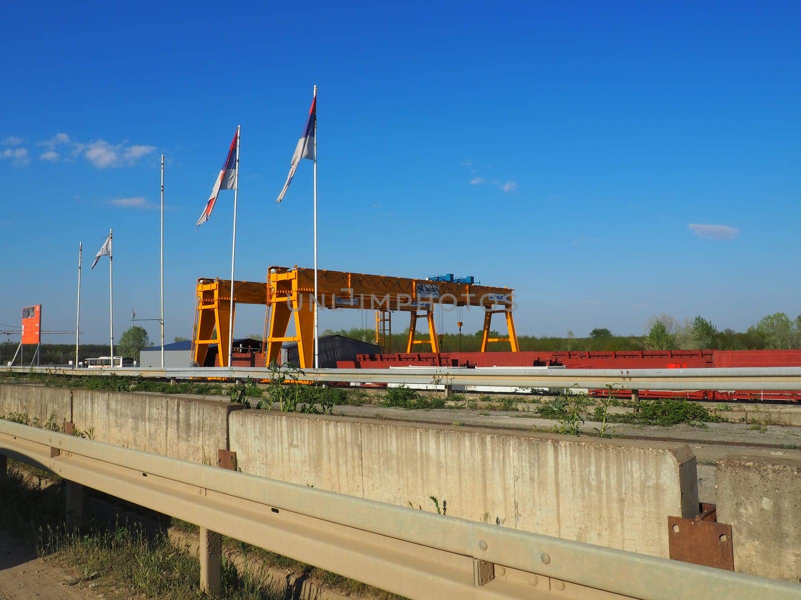 Sremska Raca, 25 April 2021. Construction of a bridge on the Sava river, crane operation, beams and concrete structures. Infrastructure project auto route Belgrade - Sarajevo. Road construction works.