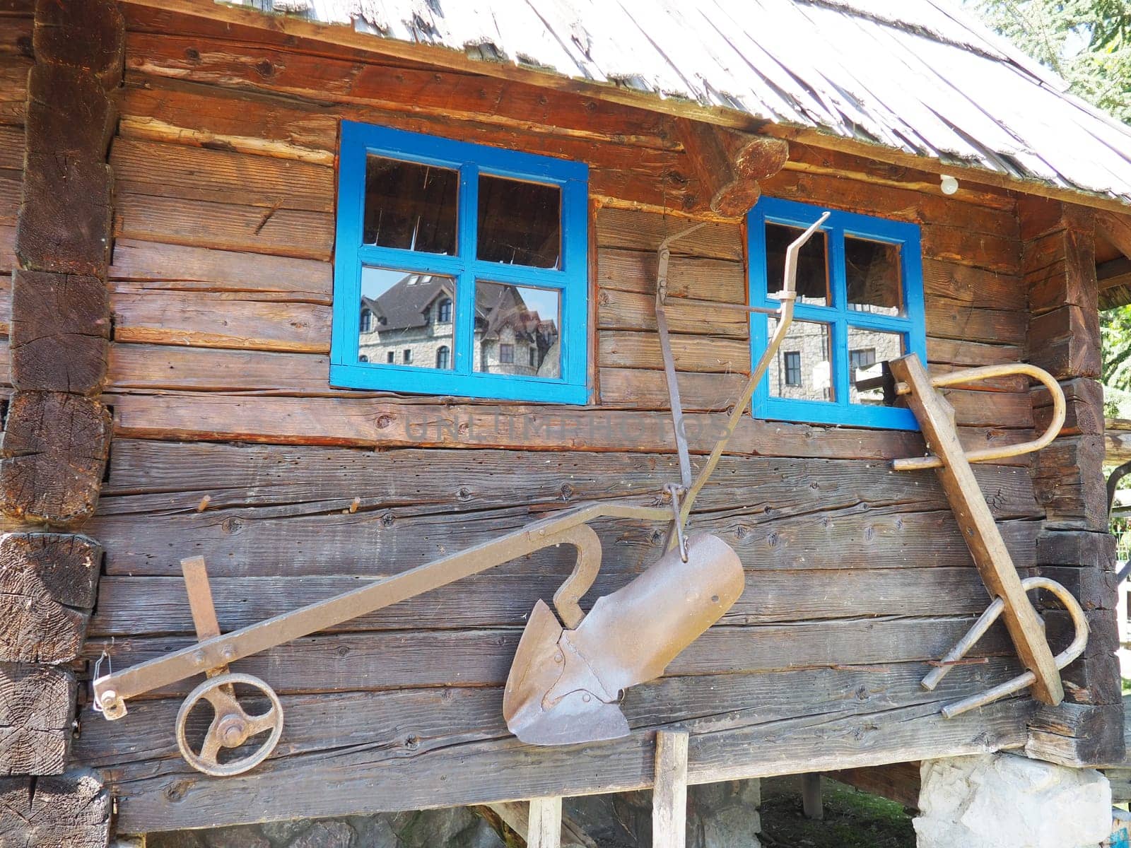 Stanisici, Bijelina, Bosnia and Herzegovina, 25 April 2021. Log village farmhouse. 19th century Bosnian mountain traditional dwelling. Restored ethno building, implements of agricultural labor