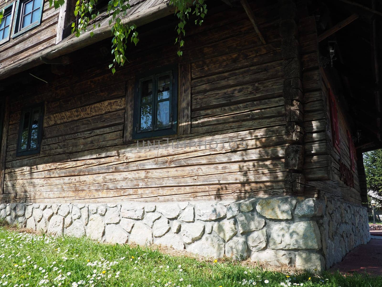 Stanisici, Bijelina, Bosnia and Herzegovina, 25 April 2021. Log village farmhouse. 19th century Bosnian mountain traditional dwelling. Restored ethno building, implements of agricultural labor