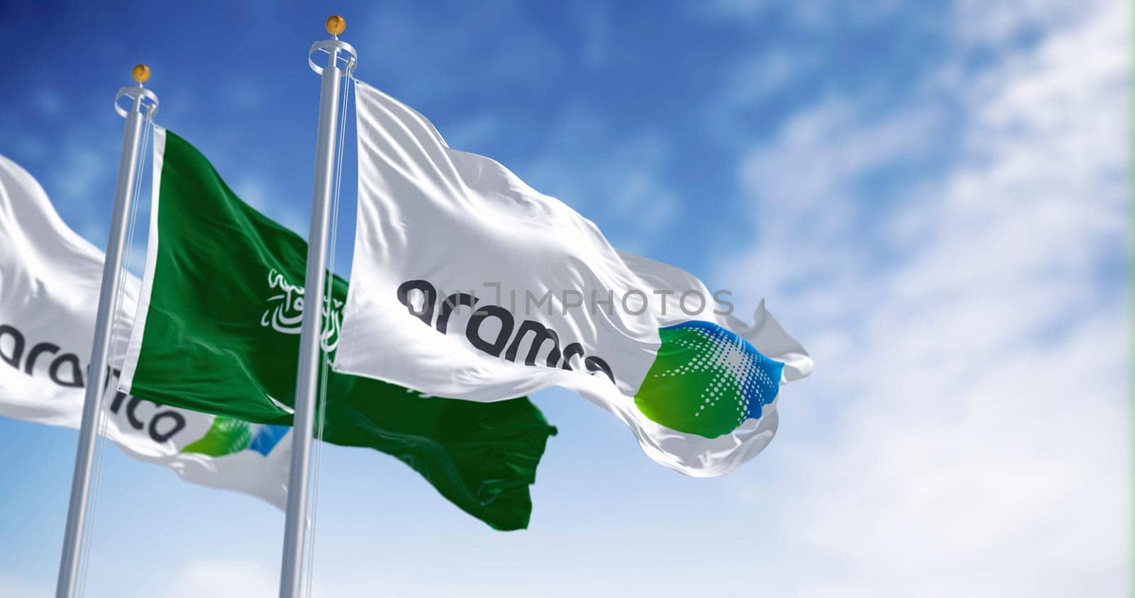 Dhahran, SA, march 2023: Flags of Aramco and Saudi Arabia waving on a clear day. Aramco is the Saudi national hydrocarbon company. Illustrative editorial 3d illustration render
