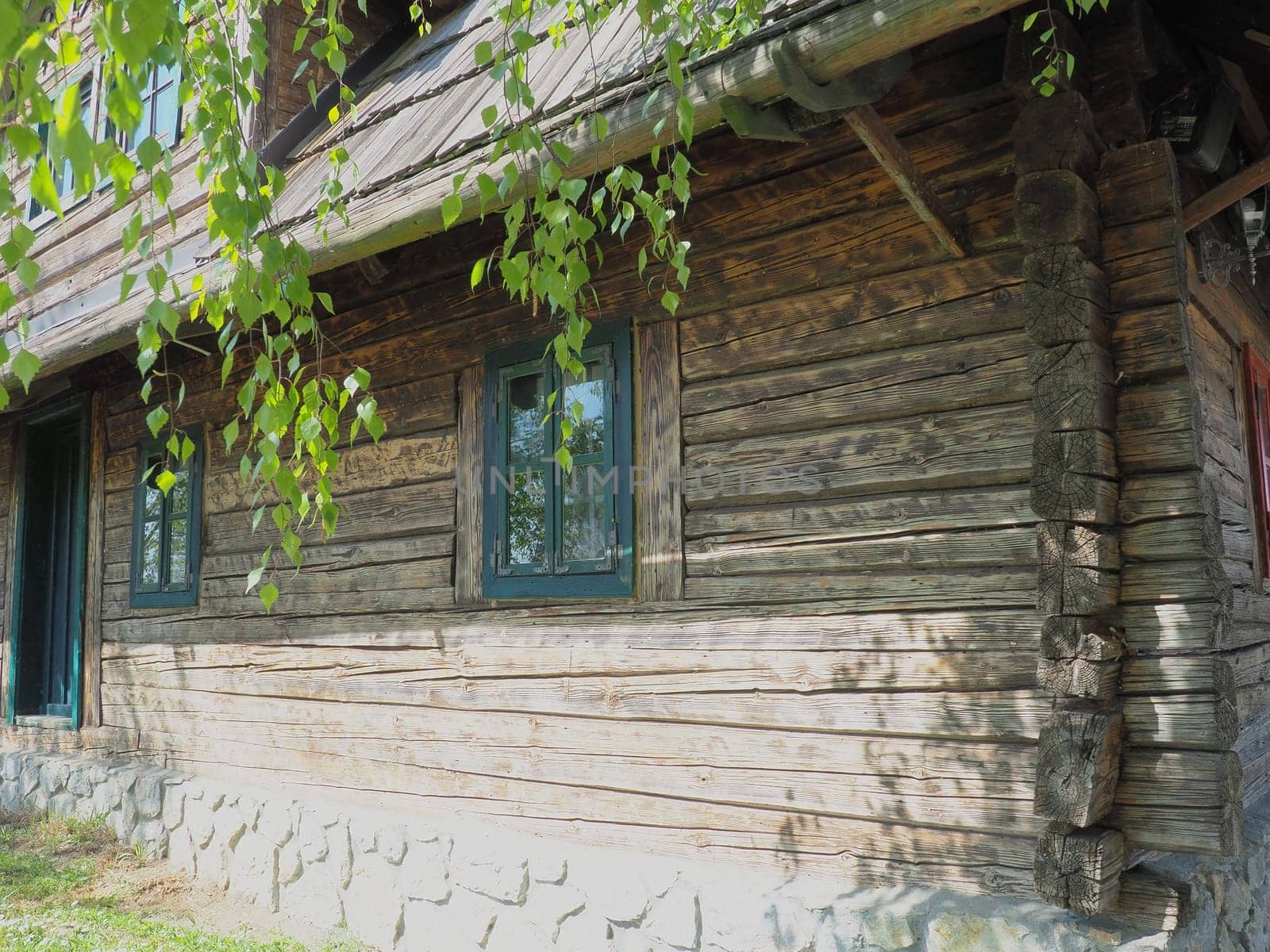 Log village farmhouse. 19th century Bosnian mountain traditional dwelling. Restored ethno building, implements of agricultural labor